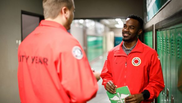 two AmeriCorps members in a conversation in the hallway