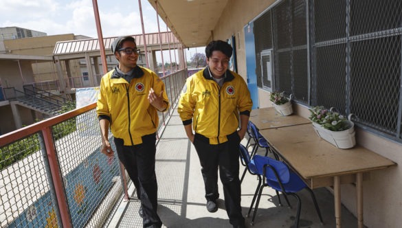 two AmeriCorps members walk together through hallway in conversation