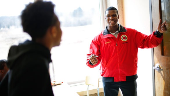 city year americorps member explains a lesson to a student as they stand facing a chalkboard