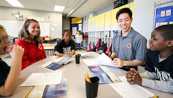 City Year AmeriCorp Members tutoring students around a work table