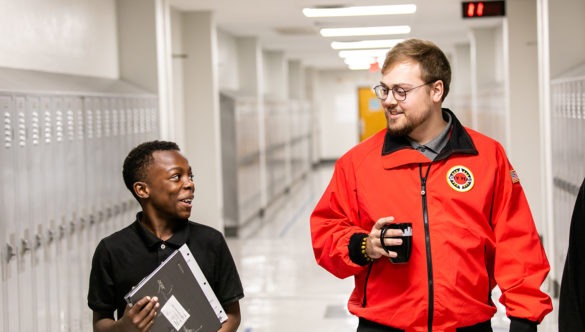 City Year AmeriCorps member with student at school