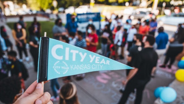 Hand holding small blue flag with text: "City Year Kansas City"