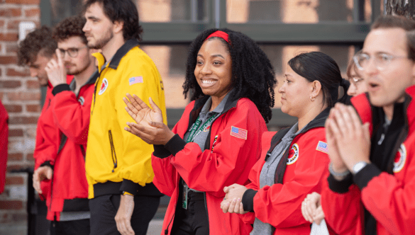 Six City Year Denver AmeriCorps members clap and greet guests