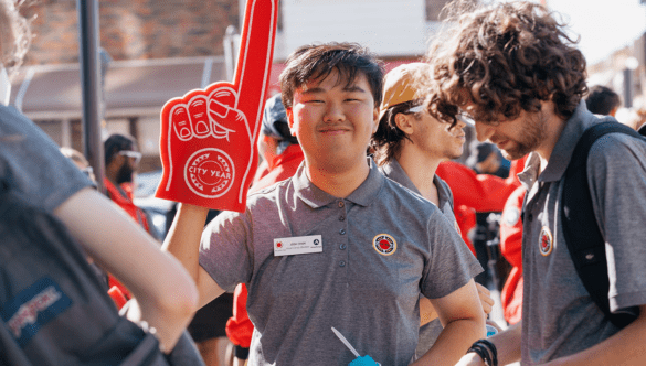 A City Year Philadelphia AmeriCorps member smiles and holds up a red foam finger.