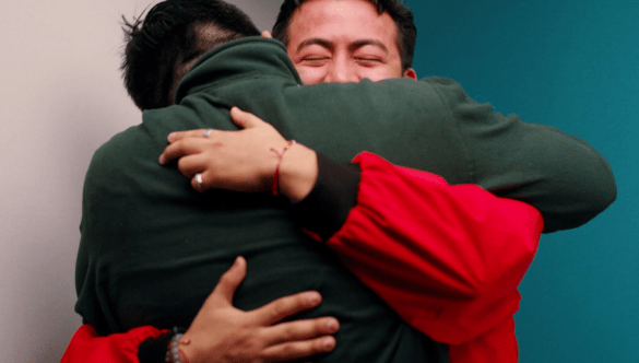 A City Year AmeriCorps member hugs the corps member who served them